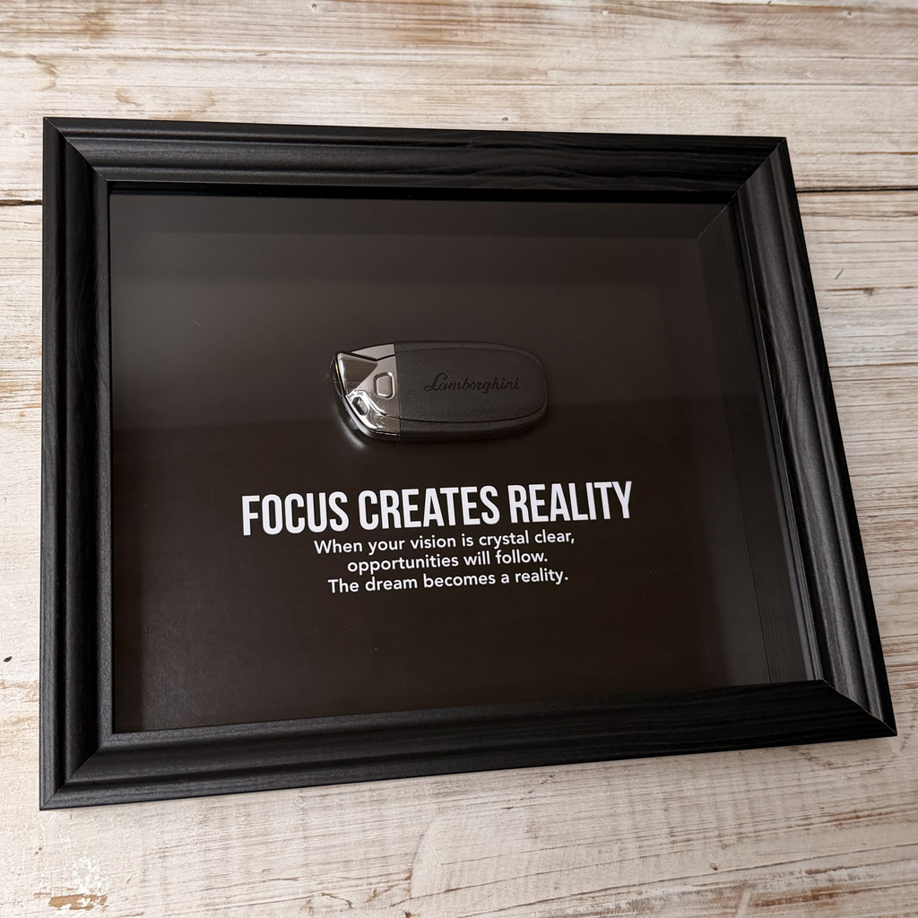 Een zwart stijlvol foto-frame met daarin een echte Lamborghini autosleutel. in het frame zien we een motivatie tekst om mensen te inspireren richting hun eigen droomwagen. 