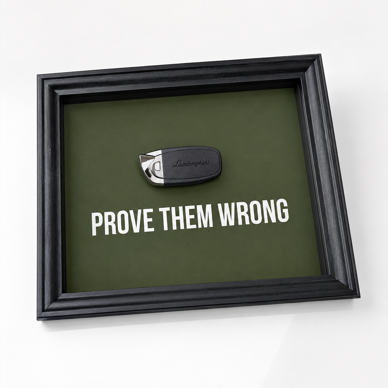 een stijlvol zwart kader met een groene achterkant, met een echte Lamborghini sleutel. de motiverende tekst in het kader leest: prove them wrong. 