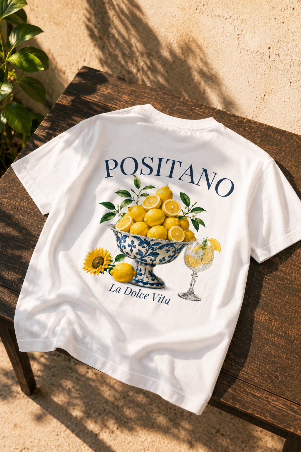 Een wit t-shirt met op de rug een zomers ontwerp met mooie citroenen in een mooi cocktailglas en zonnebloemen. de sfeer wekt een mediterraanse, Amalfi coast stijl. 