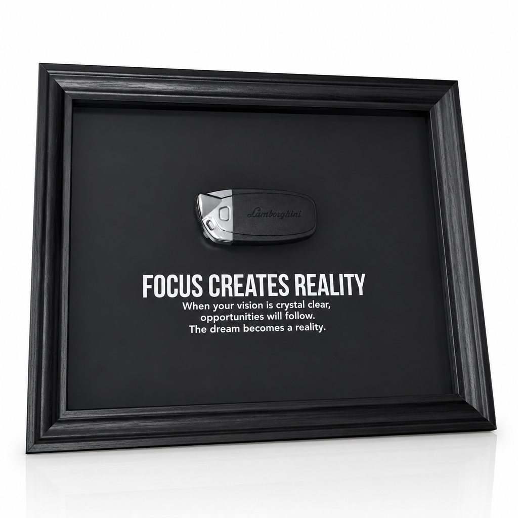 een stijlvolle zwarte kader, met een zwarte achtergrond, met een echte Lamborghini sleutel. de motiverende tekst in het kader leest: Focus creates reality. 