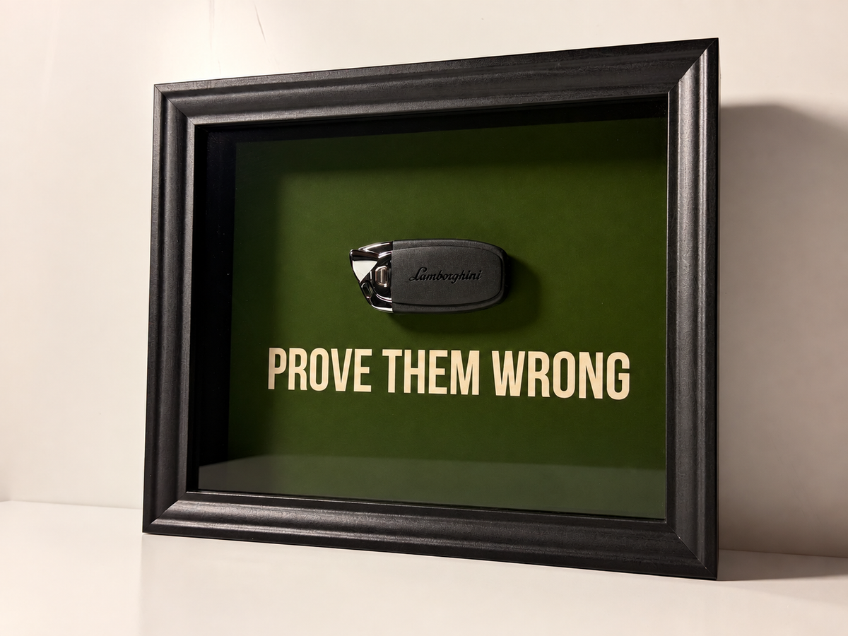 een stijlvol zwart kader met een groene achterkant, met een echte Lamborghini sleutel. de motiverende tekst in het kader leest: prove them wrong. 