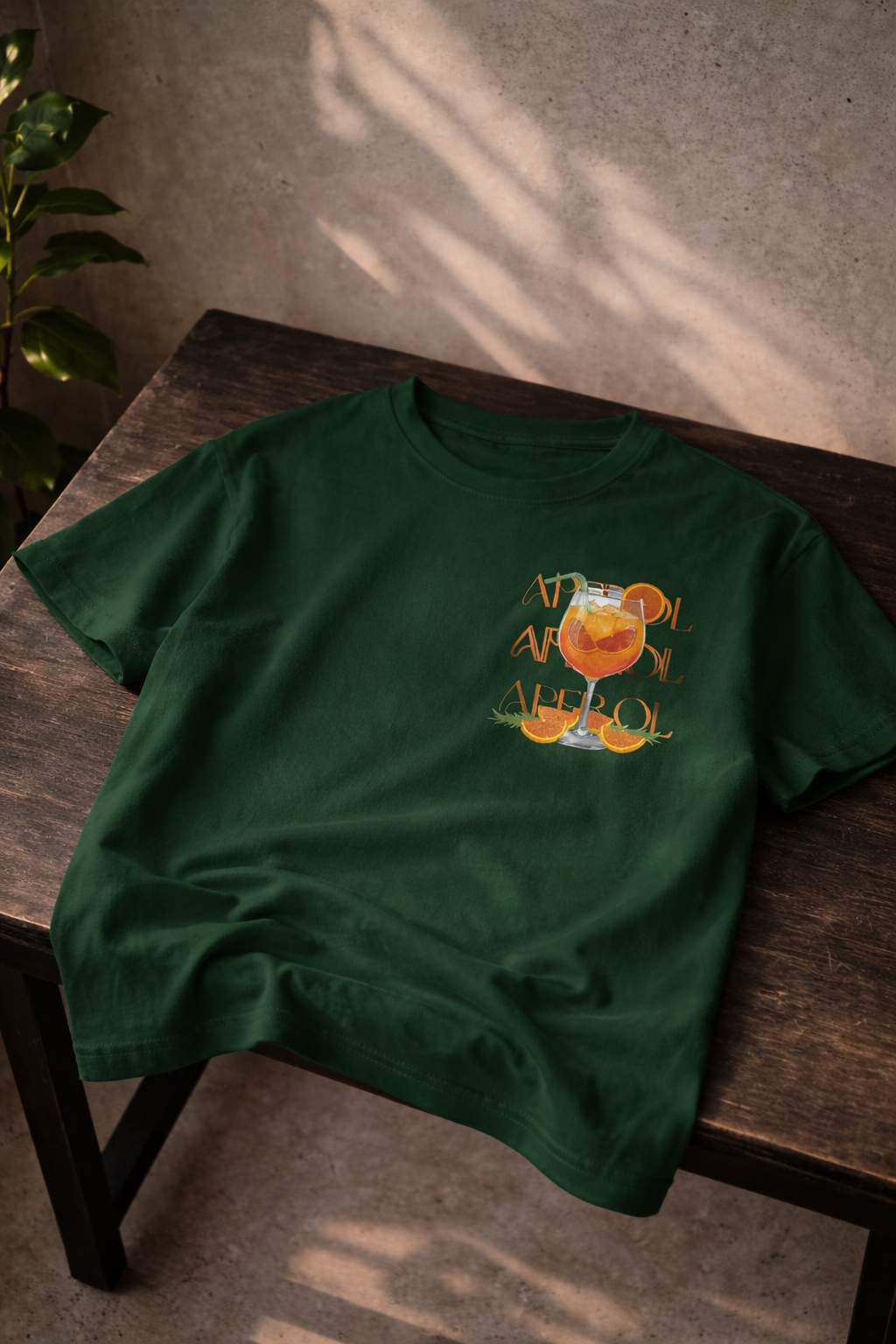 T-shirt in een donker groen kleur, met een aperol spritz zomer thema op de borst.