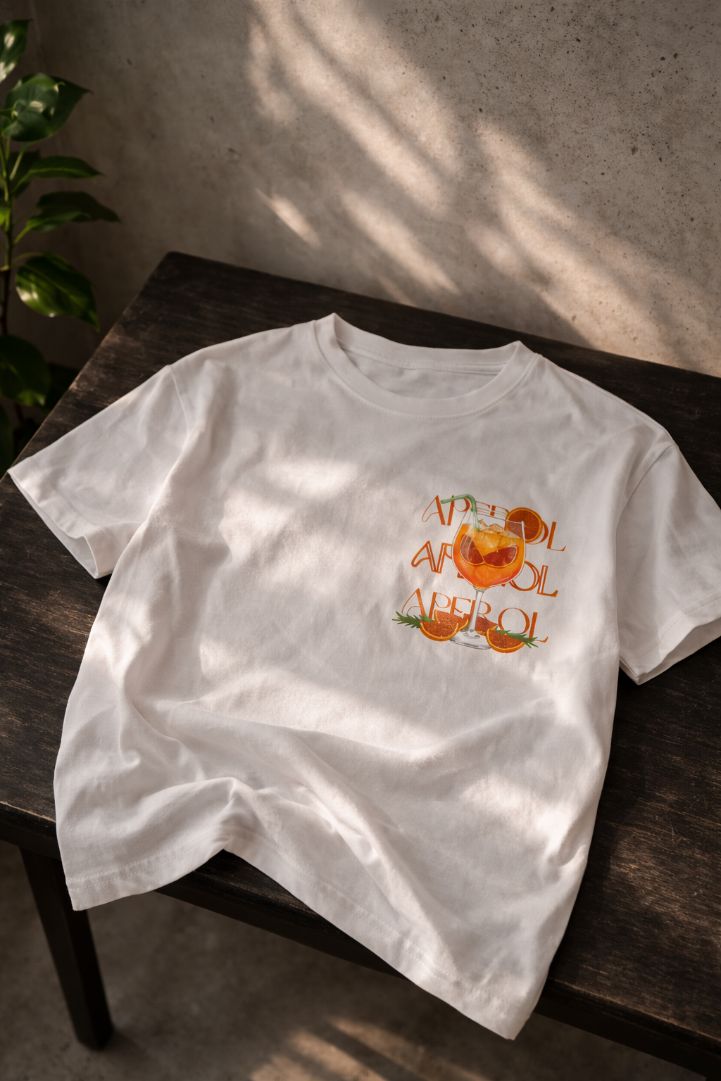 T-shirt in een wit kleur met losse fit. Met een aperol spritz geïnspireerde zomer print op de borst. 
